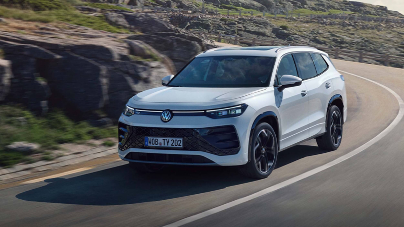 A white Tayron PHEV driving along a mountainous road