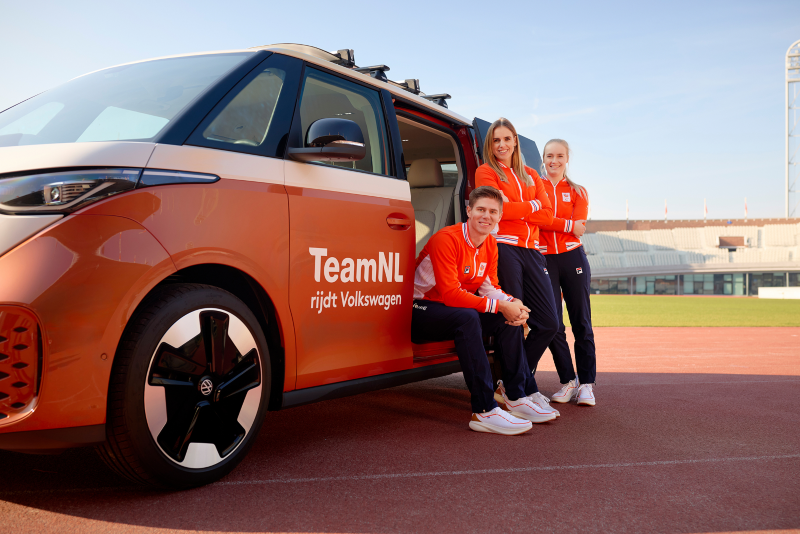 TeamNL sporters poseren staan en zitten bij een Volkswagen ID. Buzz met TeamNL bestickering