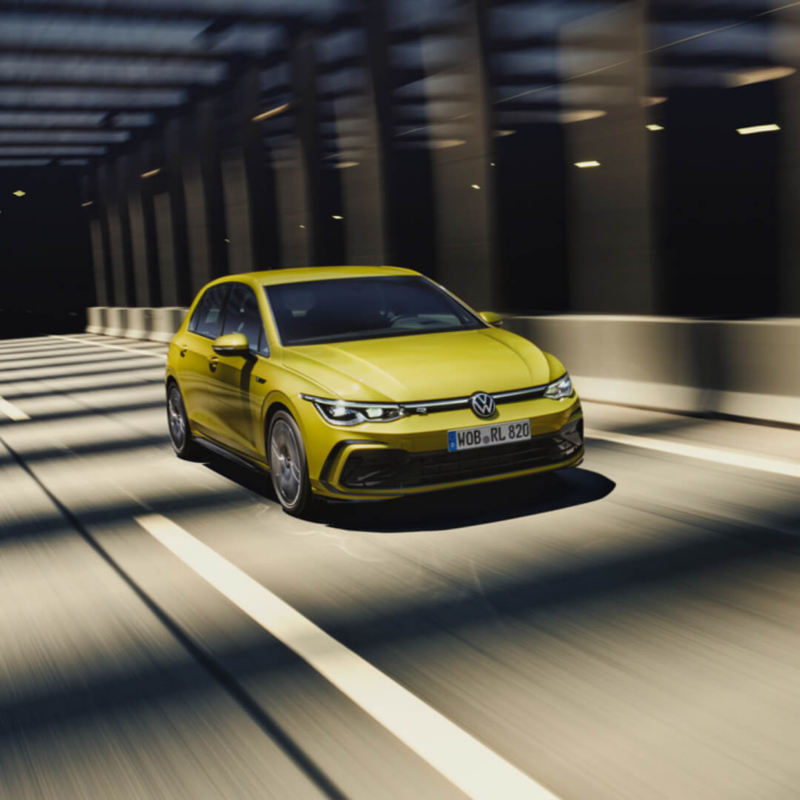 Volkswagen Golf 8 amarillo circulando por un túnel urbano