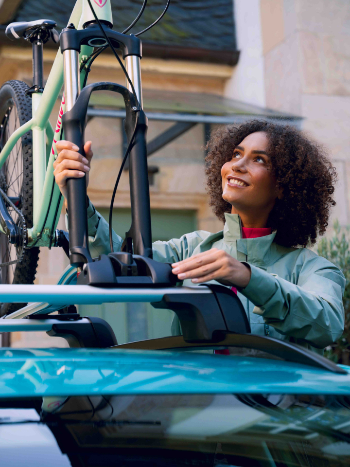 Una chica montando una bici en un portabicicletas en el techo de un Volkswagen