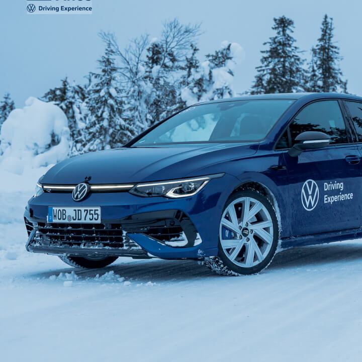 VW Golf con el logo de Driving Experience en un paisaje nevado