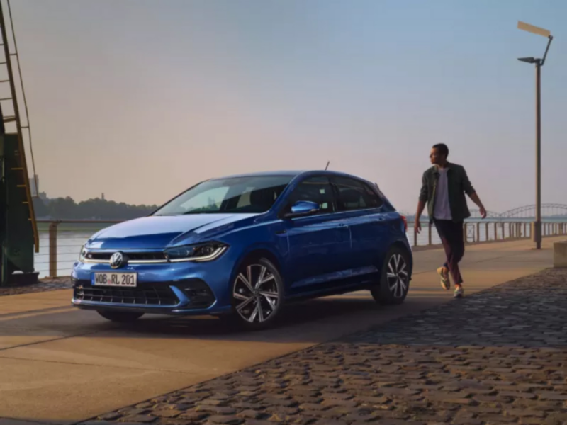 Un Volkswagen de color azul oscuro estacionado al lado de un rio