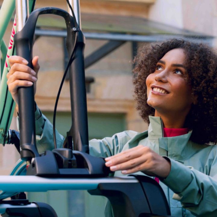 Una chica colocando una bicicleta en la parte superior de un Volkswagen