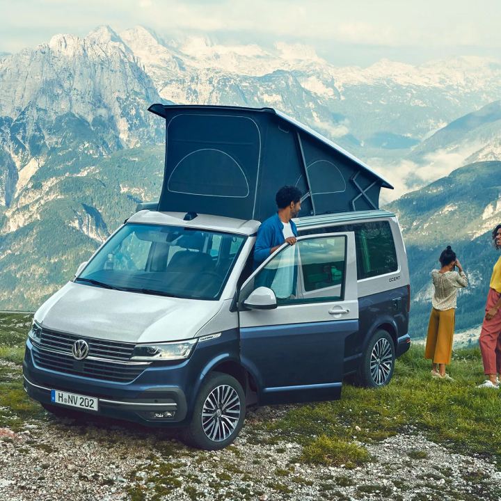 Una pareja con un Volkswagen California en la montaña