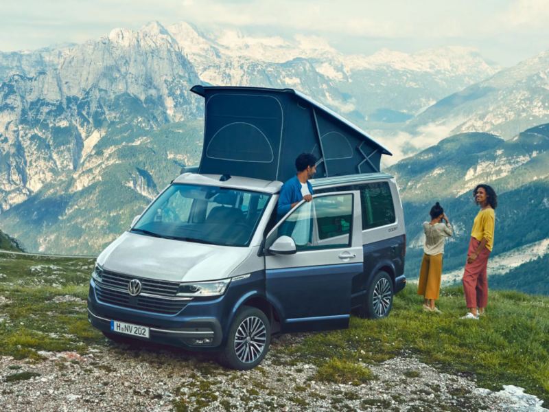 Una pareja con un Volkswagen California en la montaña