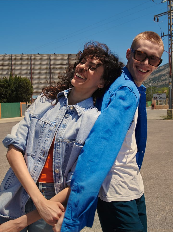 Una pareja sonriendo de pie en un exterior