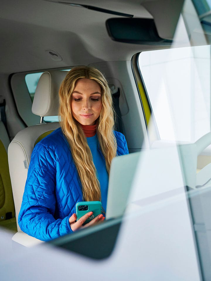 Una persona mirando el teléfono dentro de una furgo VW