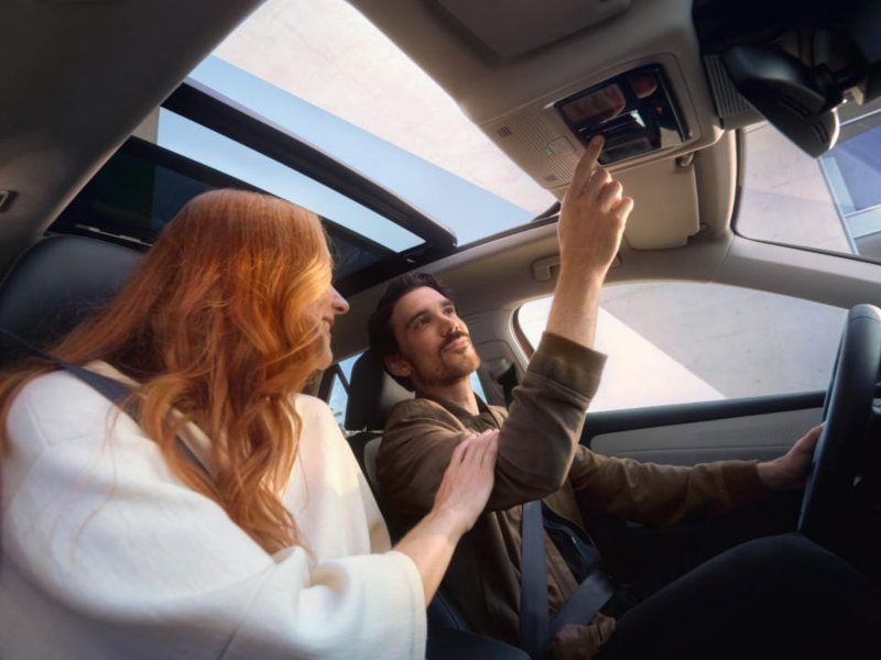 Mujer pelirroja junto a un hombre sentados dentro de un Volkswagen ID.