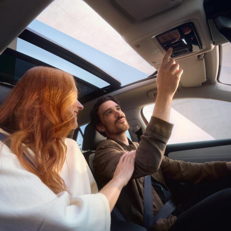 Mujer pelirroja junto a un hombre sentados dentro de un Volkswagen ID.