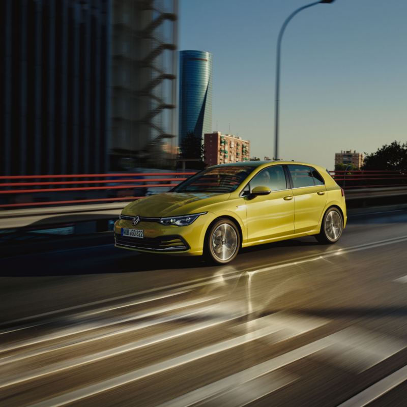 Volkswagen Golf de color amarillo circulando por carretera