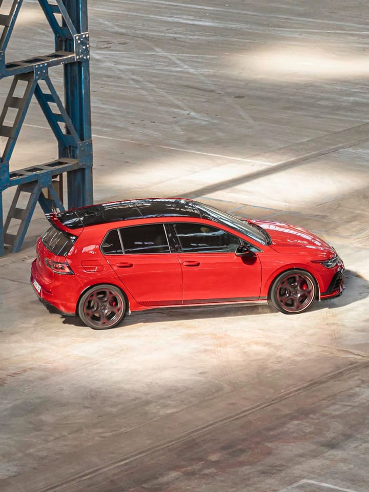 Un Golf rojo siendo conducido en una nave industrial