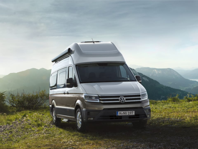 Un Volkswagen Grand California visto de frente en la montaña