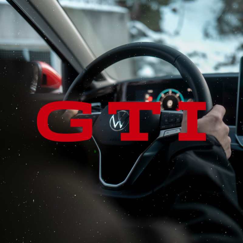 Detalle del volante de un Golf GTI con un rótulo rojo encima que dice 'GTI'