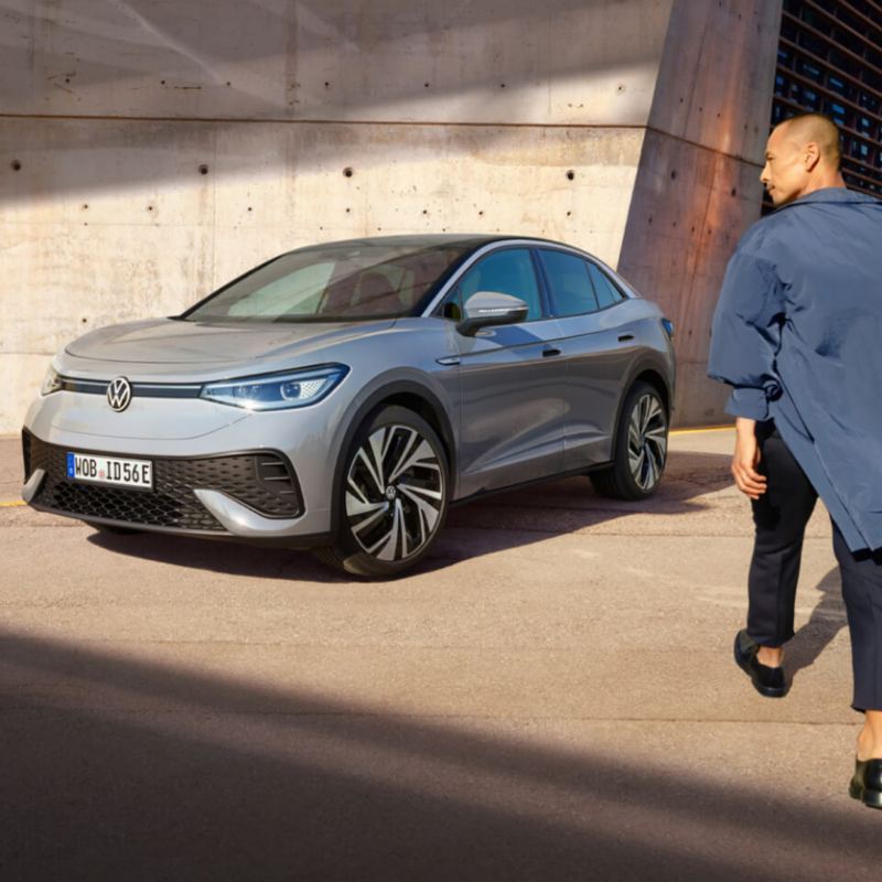 Un chico al lado de un Volkswagen ID.5 estacionado en la calle