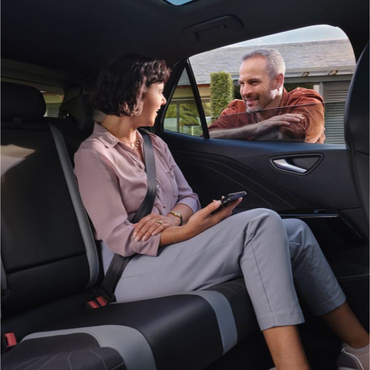 Un hombre apoyado en la ventana mirando a una chica en el interior de un Volkswagen