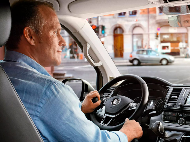 Una persona sujetando el volante de un vehículo VW