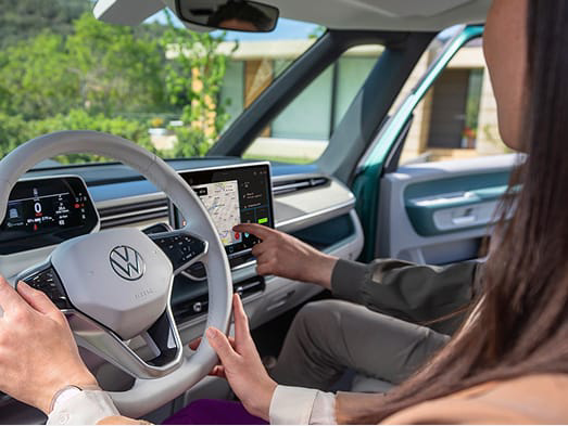 Una persona sujetando el volante de un vehículo VW
