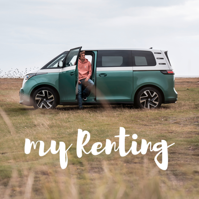Un chico sentado en una Volkswagen ID. Buzz con la puerta abierta en el campo.