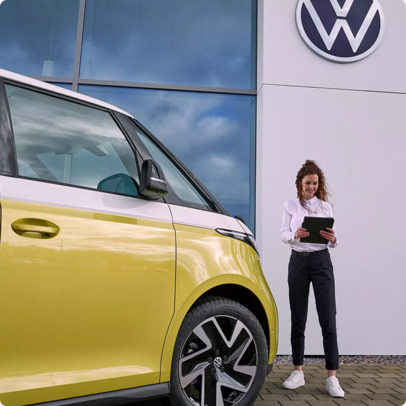 Una persona trabajadora de Volkswagen como Servicio Posventa con furgonetas Comerciales detrás