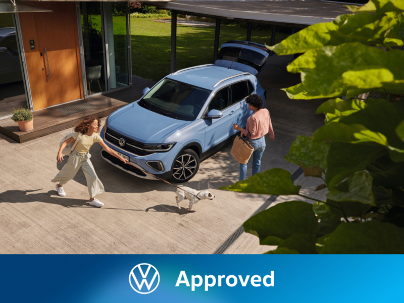 Dos chicas fuera de un Volkswagen de color azul estacionado fuera de una casa
