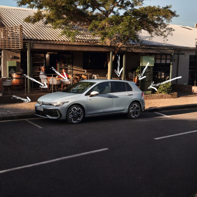 Volkswagen Golf de color gris estacionado delante de un establecimiento