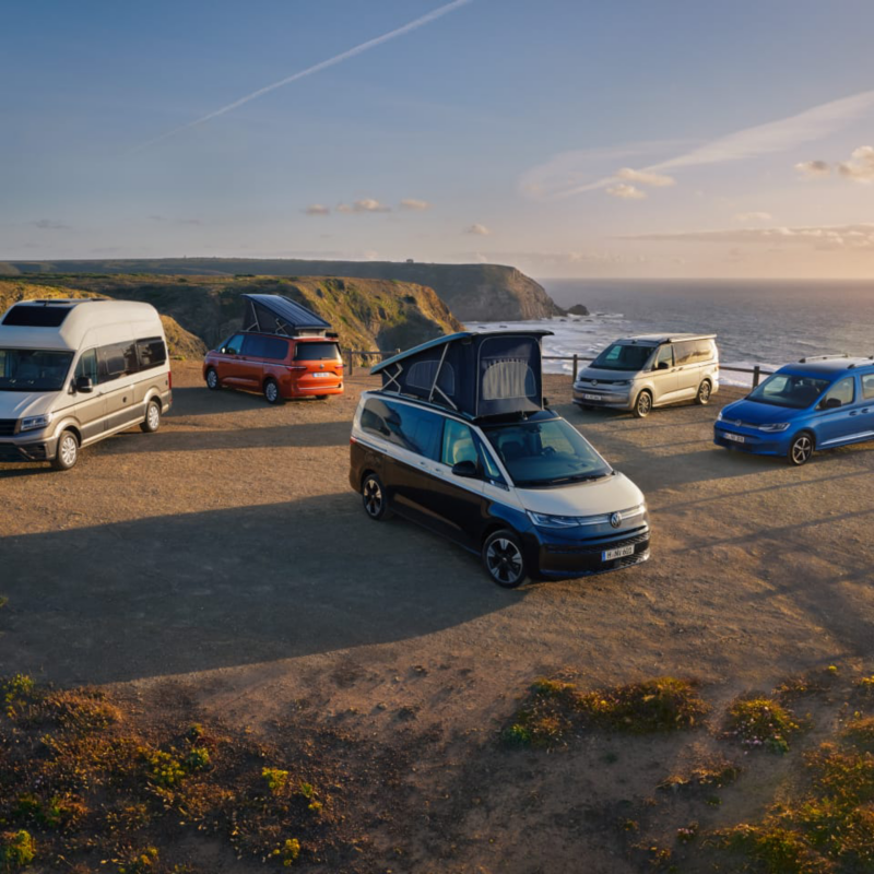 Cinco vehículos de la Gama Camper VW aparcados en un mirador.
