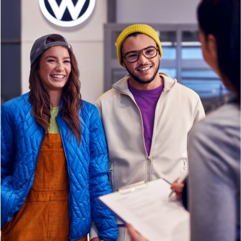Una pareja en un concesionario Volkswagen con un asistente