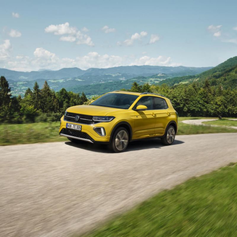 Un Volkswagen T-Cross de color amarillo circulando por una carretera