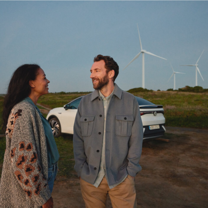 Chica hablando con un chico con un volkswagen de fondo