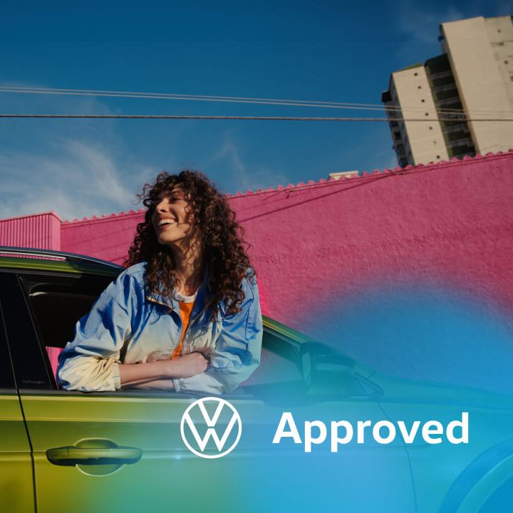 Una chica en la ventana de un Volkswagen de color verde con el logo de Approved