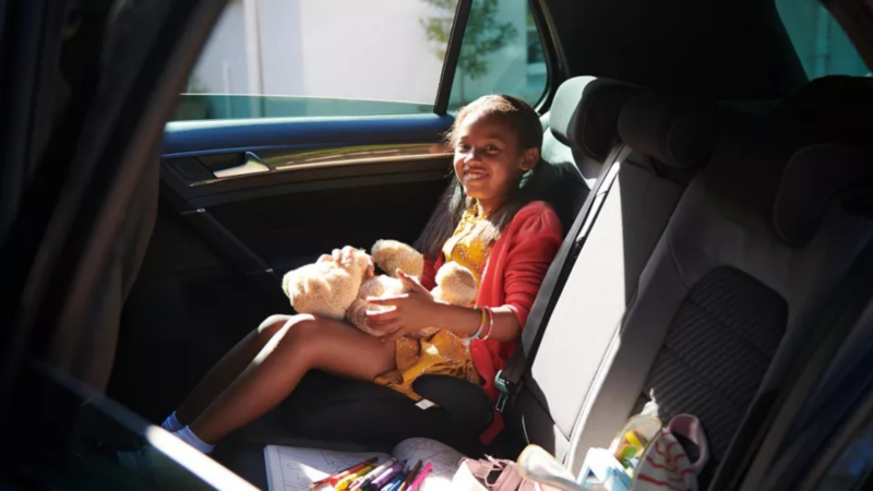 Child sitting in the back of a VW car