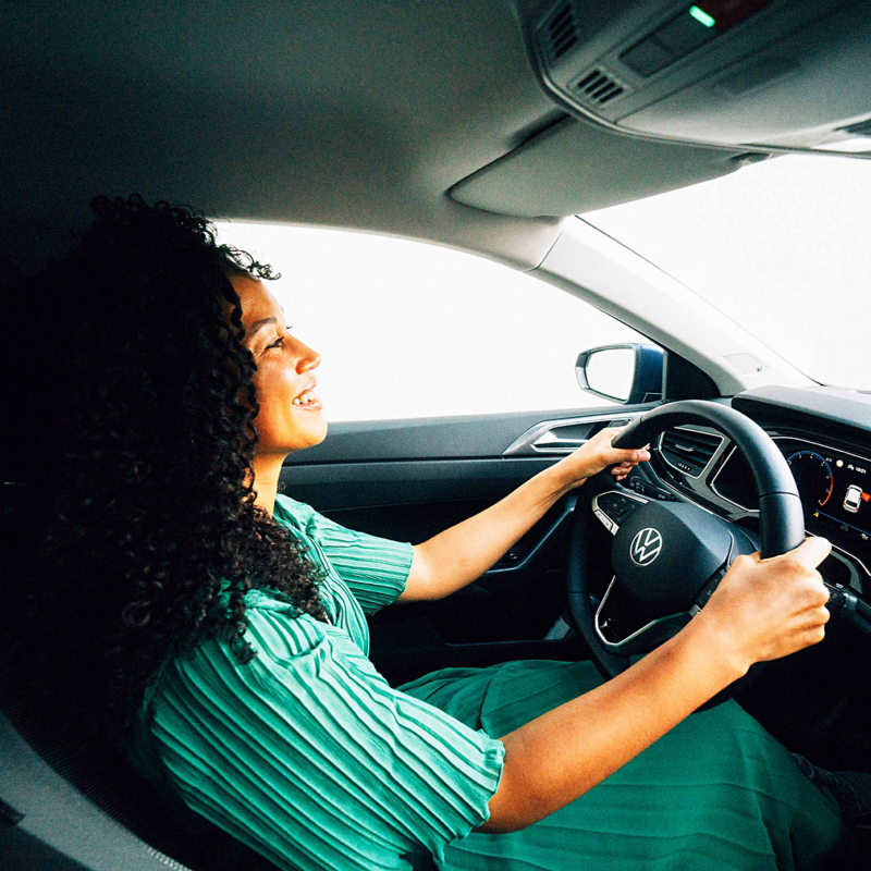 A woman sitting in the driver's seat of a VW