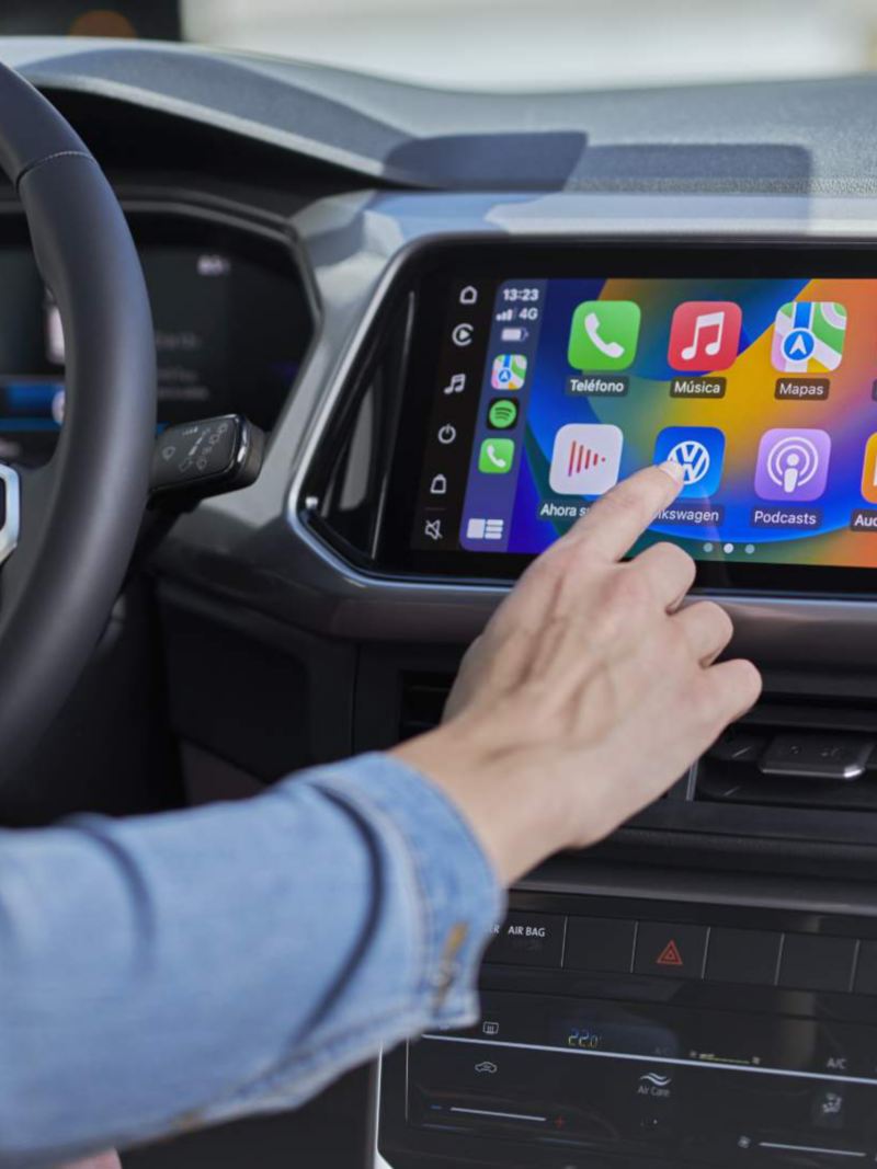 Dedo elige aplicación en pantalla táctil de camioneta Volkswagen. 