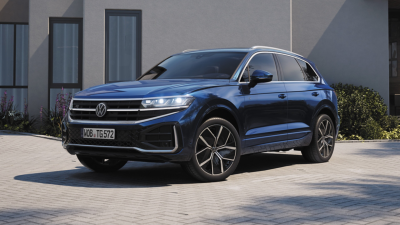 Ein blauer VW parkt vor einem Haus.