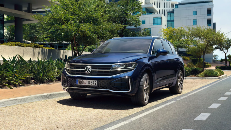 Woman sitting in front of a VW Tiguan charging at a wallbox.