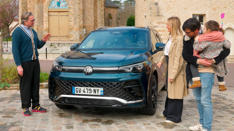 Le tone et une famille entoure le VW Tiguan vu de face.