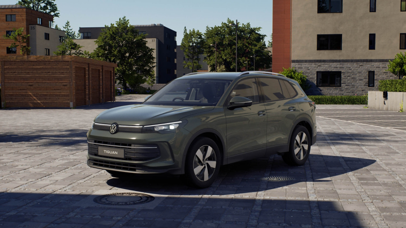 A dark green Tiguan parked in a courtyard in front of a building.