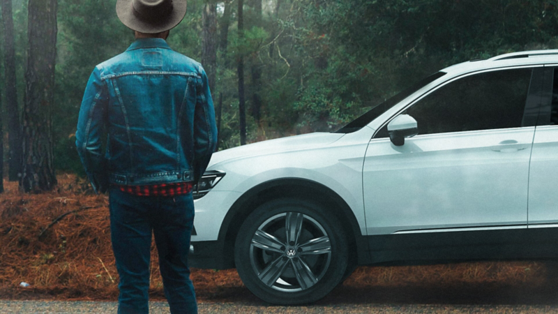 Tiguan 2020, el SUV seguro con mejor desempeño estacionado sobre carretera frente a hombre parado