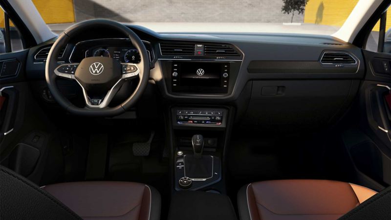 Interior de Volkswagen Tiguan 2022 - Volante multifunciones, panel con pantalla, palanca y asientos.