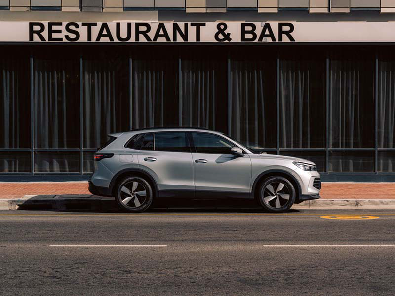 A grey ID. Tiguan parked outside of a restaurant.