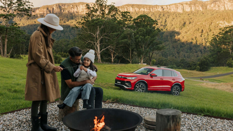 Family at a campsite with Volkswagen Tiguan in a field
