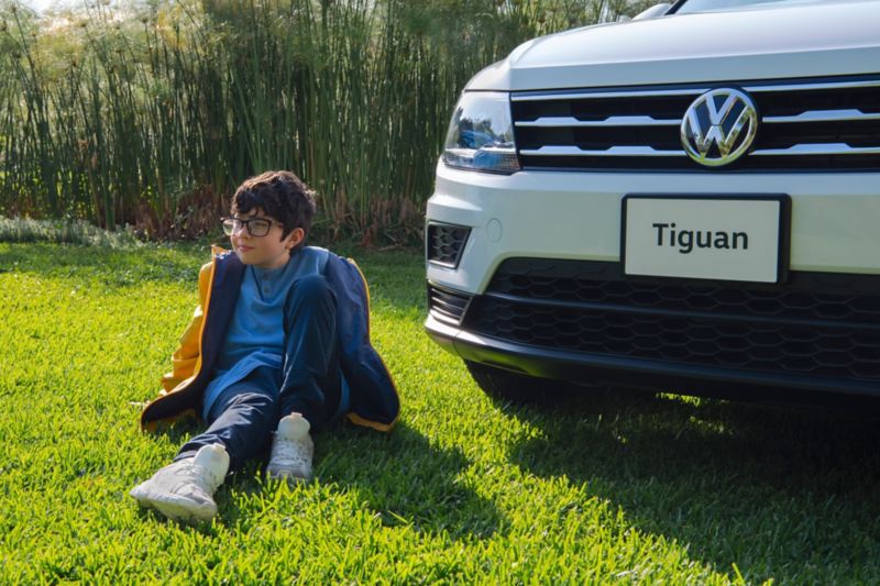 Niño sentado frente a Tiguan 2020,  camioneta familiar VW destacada por su seguridad y potencia