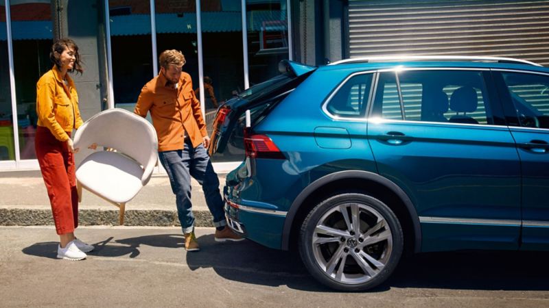 A couple opening the tailgate of the VW Tiguan