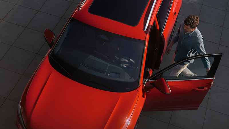 An aerial view of a woman entering a Volkswagen Tiguan