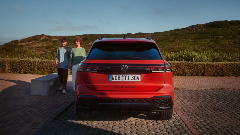 The back of a red VW Tiguan against a hilly background