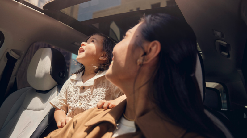 A woman and child looking through the sunroof of a VW Tiguan