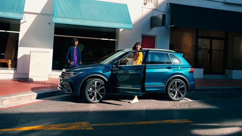 Femme près de la porte ouverte côté conducteur d'un VW Tiguan