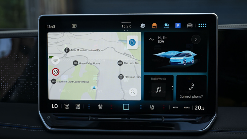 A young woman on the driver seat of her VW Tiguan interacting with the digital voice assistant 