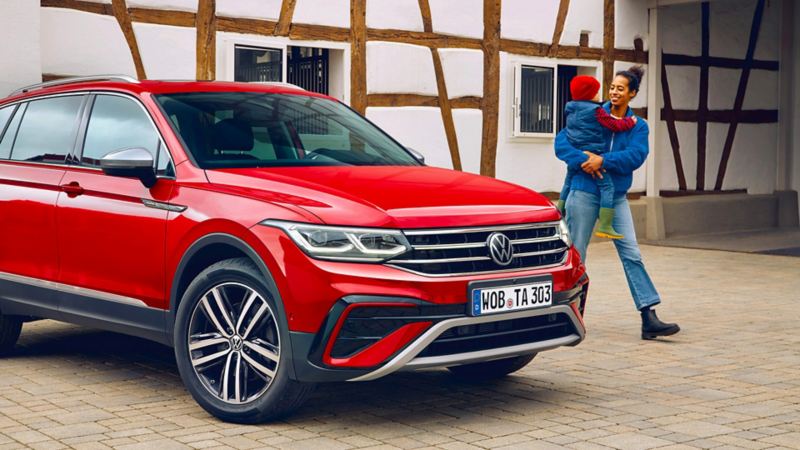 VW Nouveau Tiguan Allspace rougé garé devant un mur en colombages