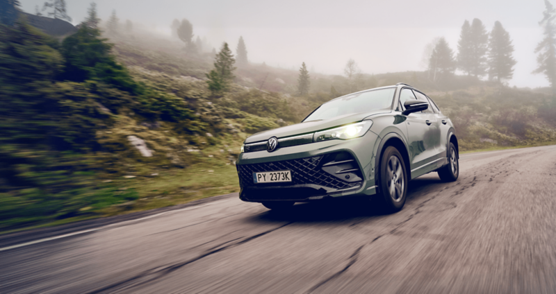 Tiguan jadący przez leśną drogę